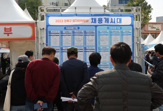 지난달 25일 오후 서울 강북구청 광장에서 열린 2023 강북구 일자리박람회에서 참가자들이 채용게시대를 살펴보고 있다. [연합뉴스]